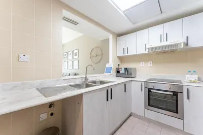 a kitchen with white cabinets and a sink at HAVN -1 Bedroom Unit in Dubai Marina, Marina View in Dubai