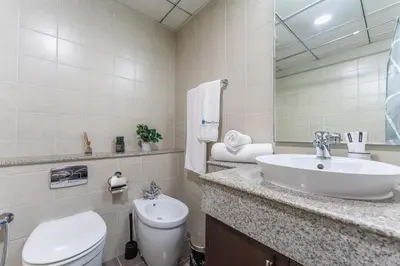 a bathroom with a sink and a toilet and a mirror at HAVN -1 Bedroom Unit in Dubai Marina, Marina View in Dubai