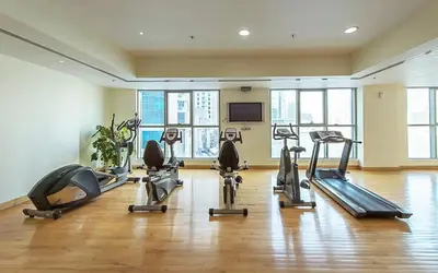 a gym with several tread machines in a room at HAVN -1 Bedroom Unit in Dubai Marina, Marina View in Dubai