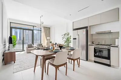 a kitchen and living room with a table and chairs at Silkhaus Full Marina View 2BDR in Unique New Tower in Dubai