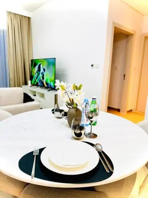 a white table with a white plate and silverware at Park Heights Deluxe 1bedroom in Dubai