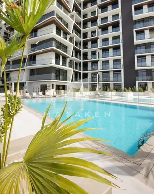 a large apartment building with a large swimming pool at Modern 1br Jvc Balcony & Free Parking Pool in Dubai