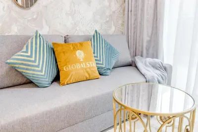 a couch with three pillows on it with a table at GlobalStay Reva & Vera Residences Business Bay Apartments in Dubai