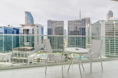 a table and chairs on a balcony with a city skyline at GlobalStay Reva & Vera Residences Business Bay Apartments in Dubai