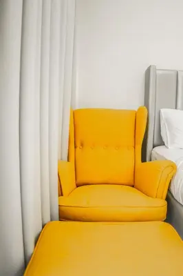 a yellow chair sitting in front of a window at Perfect Studio Apartment Near to Metro Station in Dubai