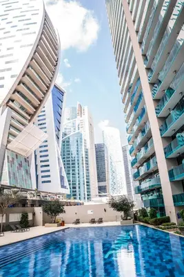 a pool in the middle of a city with tall buildings at Perfect Studio Apartment Near to Metro Station in Dubai