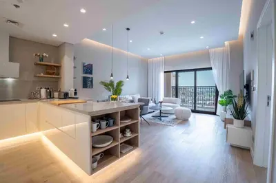 a kitchen and living room with a counter and a table at Veluxa - Fantastic 1 Bed - in Jumeirah Golf Estate! in Dubai