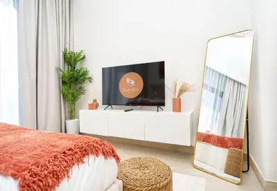 a living room with a tv on a white dresser at EasyGo - Azizi Riviera 15 Community View in Dubai