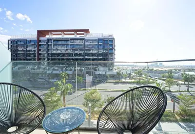 two chairs on a balcony with a view of a building at EasyGo - Azizi Riviera 15 Community View in Dubai