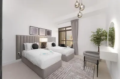 a hotel room with two beds and a chair at Beautiful 2 Bedroom Retreat in the Heart of JBR in Dubai