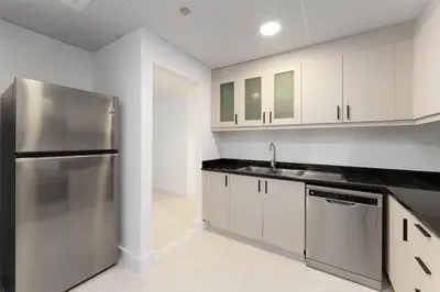 a kitchen with white cabinets and a stainless steel refrigerator at Beautiful 2 Bedroom Retreat in the Heart of JBR in Dubai