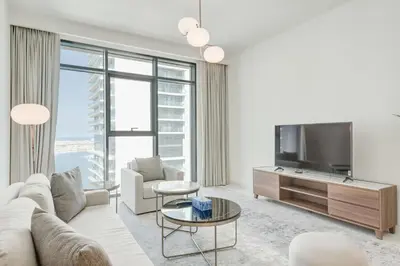 a living room with a white couch and a tv at Silkhaus Exquisite Sea View 1BDR At Marina Vista in Dubai