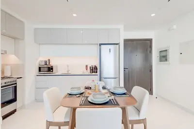 a kitchen and dining room with a wooden table and chairs at Silkhaus Exquisite Sea View 1BDR At Marina Vista in Dubai