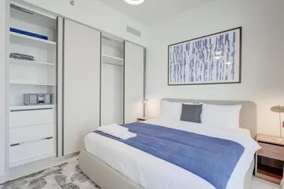 a bedroom with a large bed and a closet at Silkhaus Exquisite Sea View 1BDR At Marina Vista in Dubai