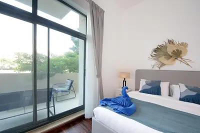 a bedroom with a bed and a large window at New Arabian The Links Canal 1 BR The Greens in Dubai