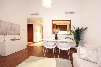 a living room with a table and some chairs at New Arabian The Links Canal 1 BR The Greens in Dubai