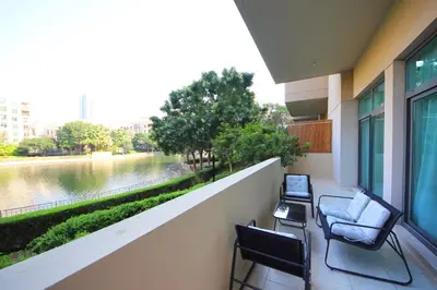 a balcony with chairs and a view of a river at New Arabian The Links Canal 1 BR The Greens in Dubai