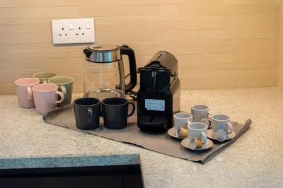a bunch of coffee cups sitting on a counter at Elite Escape Holiday Home - 2 BHK Getaway with Burj Khalifa View and Dubai Mall Access - 1507 in Dubai