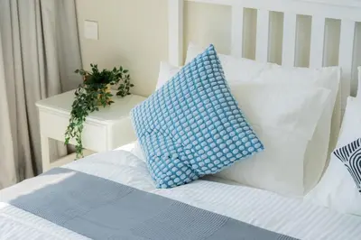 a bed with a blue and white pillow on it at Elite Escape Holiday Home - 2 BHK Getaway with Burj Khalifa View and Dubai Mall Access - 1507 in Dubai