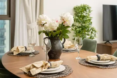 a wooden table with a vase with white flowers on it at Prime Retreats @ Burj Crown by Emaar, Downtown dubai in Dubai