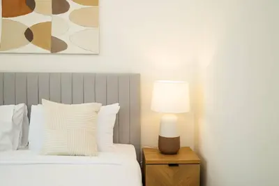 a bedroom with a bed with a lamp on a night stand at Prime Retreats @ Burj Crown by Emaar, Downtown dubai in Dubai