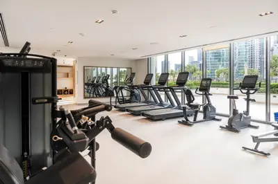 a gym with treadmills and elliptical machines at Prime Retreats @ Burj Crown by Emaar, Downtown dubai in Dubai