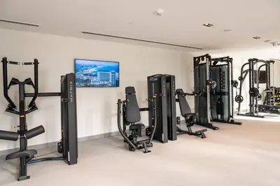 a gym with several rows of exercise equipment in a room at Prime Retreats @ Burj Crown by Emaar, Downtown dubai in Dubai