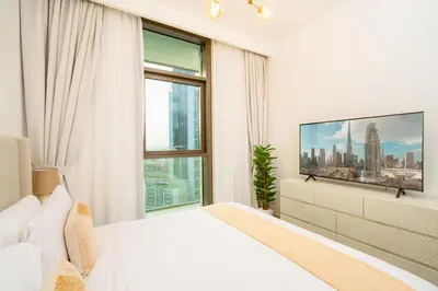 a bedroom with a white bed and a large window at Prime Retreats @ Burj Crown by Emaar, Downtown dubai in Dubai