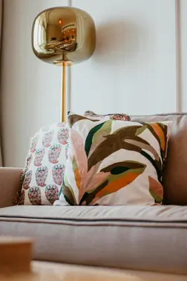 a lamp sitting on top of a couch with a pillow at Oceanfront Escape: Stylish 1 BR in Beachfront in Dubai