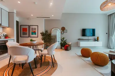 a living room with a table and chairs at Oceanfront Escape: Stylish 1 BR in Beachfront in Dubai
