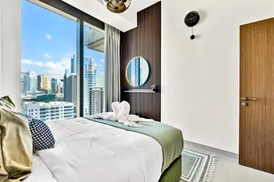 a bedroom with a bed and a large window at Luxurious Marina & Sea views 1BR near Blue Waters Dubai Marina By Maxx Value Homes in Dubai