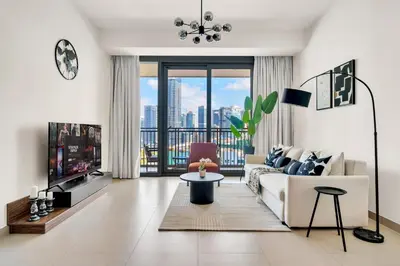 a living room with a couch and a tv at Luxurious Marina & Sea views 1BR near Blue Waters Dubai Marina By Maxx Value Homes in Dubai