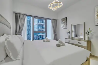 a white bedroom with a large bed with teddy bears on it at MAJESTIC Act Two 2BR- 27th Floor Burj Khalifa- Downtown Dubai in Dubai