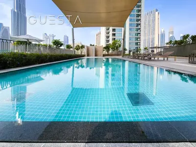 a swimming pool in a city with tall buildings at Downtown Views II by Emaar, Downtown Dubai in Dubai