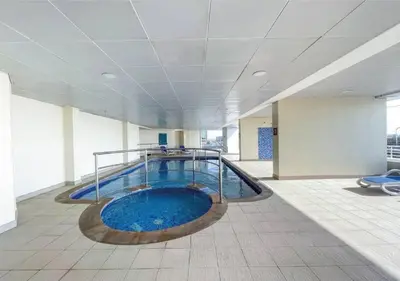 a large swimming pool in an office building at HAVN - Studio Apartment in JLT, with Lake Views in Dubai