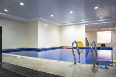 an indoor swimming pool with a swimming pool at Your Silicon Oasis Comfort Haven in Dubai