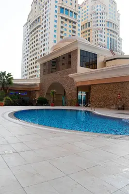 a building with a swimming pool in front of some tall buildings at Your Silicon Oasis Comfort Haven in Dubai