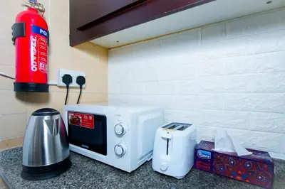 a microwave sitting on top of a kitchen counter at Your Silicon Oasis Comfort Haven in Dubai