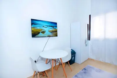 a white table and four chairs in a room at Your Silicon Oasis Comfort Haven in Dubai
