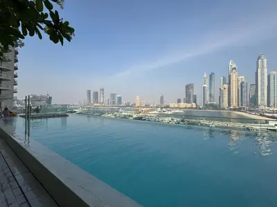 a large pool of water with a city in the background at Luxury beach house with mesmerizing skyline view in Dubai