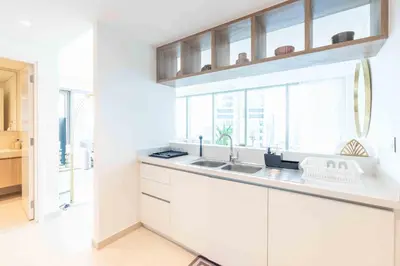 a white kitchen with a sink and windows at Downtown Views II Burj Khalifa View, Downtown Dubai - Mint Stay in Dubai
