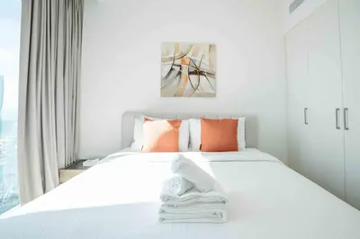 a bedroom with a white bed with towels on it at Downtown Views II Burj Khalifa View, Downtown Dubai - Mint Stay in Dubai
