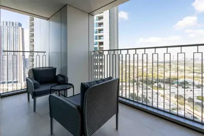 a balcony with two chairs and a view of a city at Downtown Views II Burj Khalifa View, Downtown Dubai - Mint Stay in Dubai