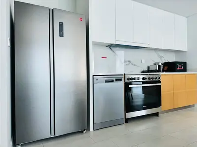 a kitchen with a stainless steel refrigerator and a stove at Luxury Brand New 2 Bhk Apartment In La Vie -jbr in Dubai