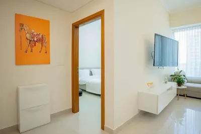 a white room with a bed and a television at Cozy Spacious Apartment 1BR in Dubai
