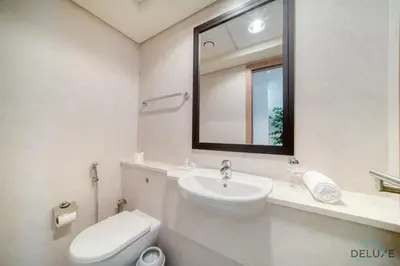 a bathroom with a sink and a toilet and a mirror at Special Offer Stylish 1BR with Scenic Views & Pool by Deluxe Holiday Homes in Dubai