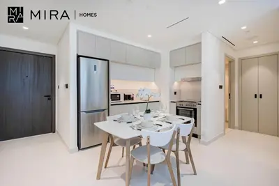 a white kitchen with a white table and chairs at Mira Holiday Homes-Marina Vista Emaar Beachfront in Dubai