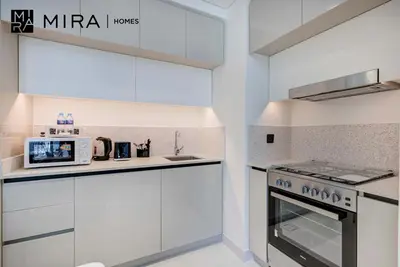 a white kitchen with a stove and a microwave at Mira Holiday Homes-Marina Vista Emaar Beachfront in Dubai