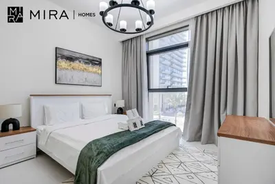 a bedroom with a bed and a large window at Mira Holiday Homes-Marina Vista Emaar Beachfront in Dubai