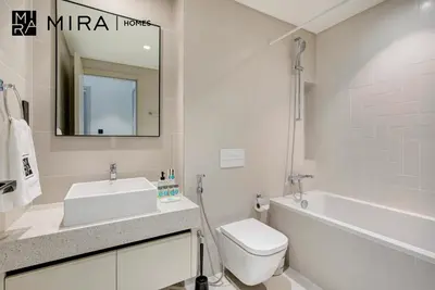 a bathroom with a sink and a toilet and a bath tub at Mira Holiday Homes-Marina Vista Emaar Beachfront in Dubai
